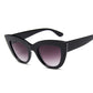 A pair of retro-inspired vintage cat-eye sunglasses with a black frame and purple lenses