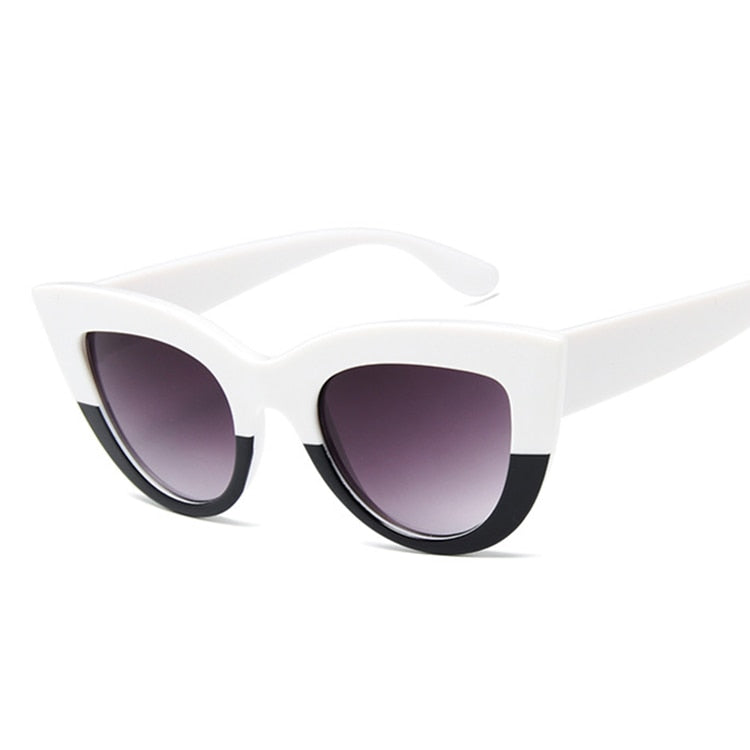  pair of black cat-eye sunglasses perched on a white surface