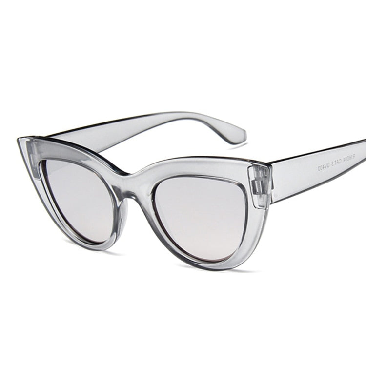 A pair of vintage cat-eye sunglasses with a silver frame and silver lenses.